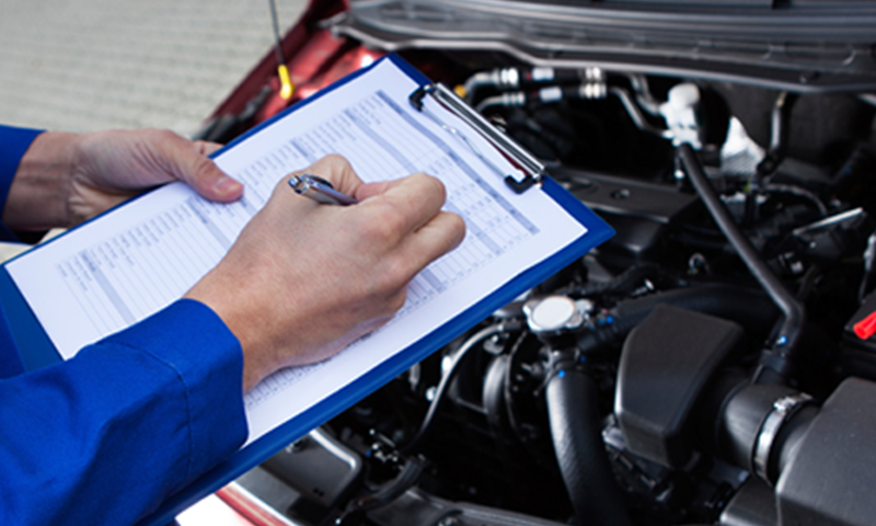 A mechanic reviewing a check list for maintenance on a vehicle